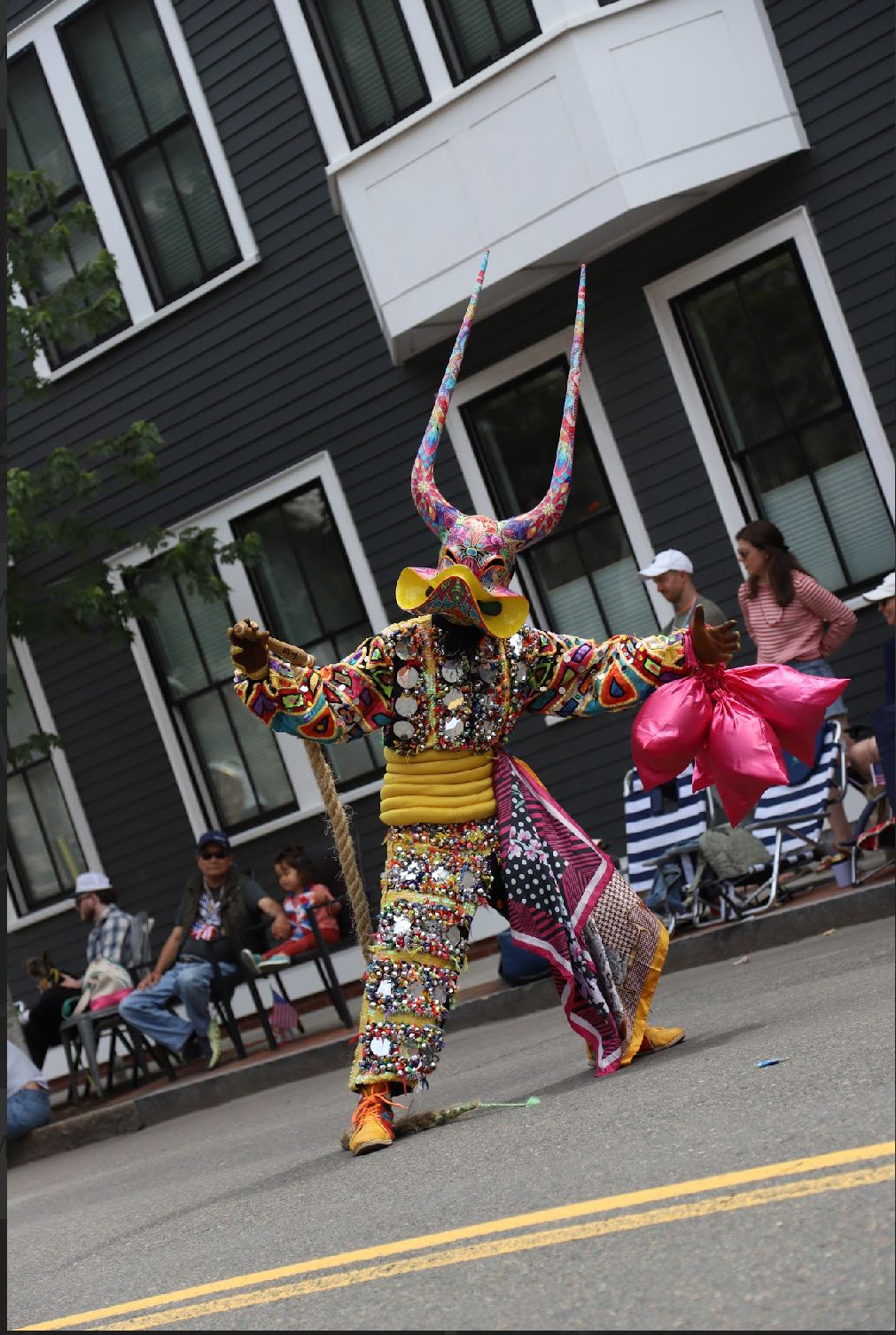 Lechón performer in a horned mask and beaded suit
